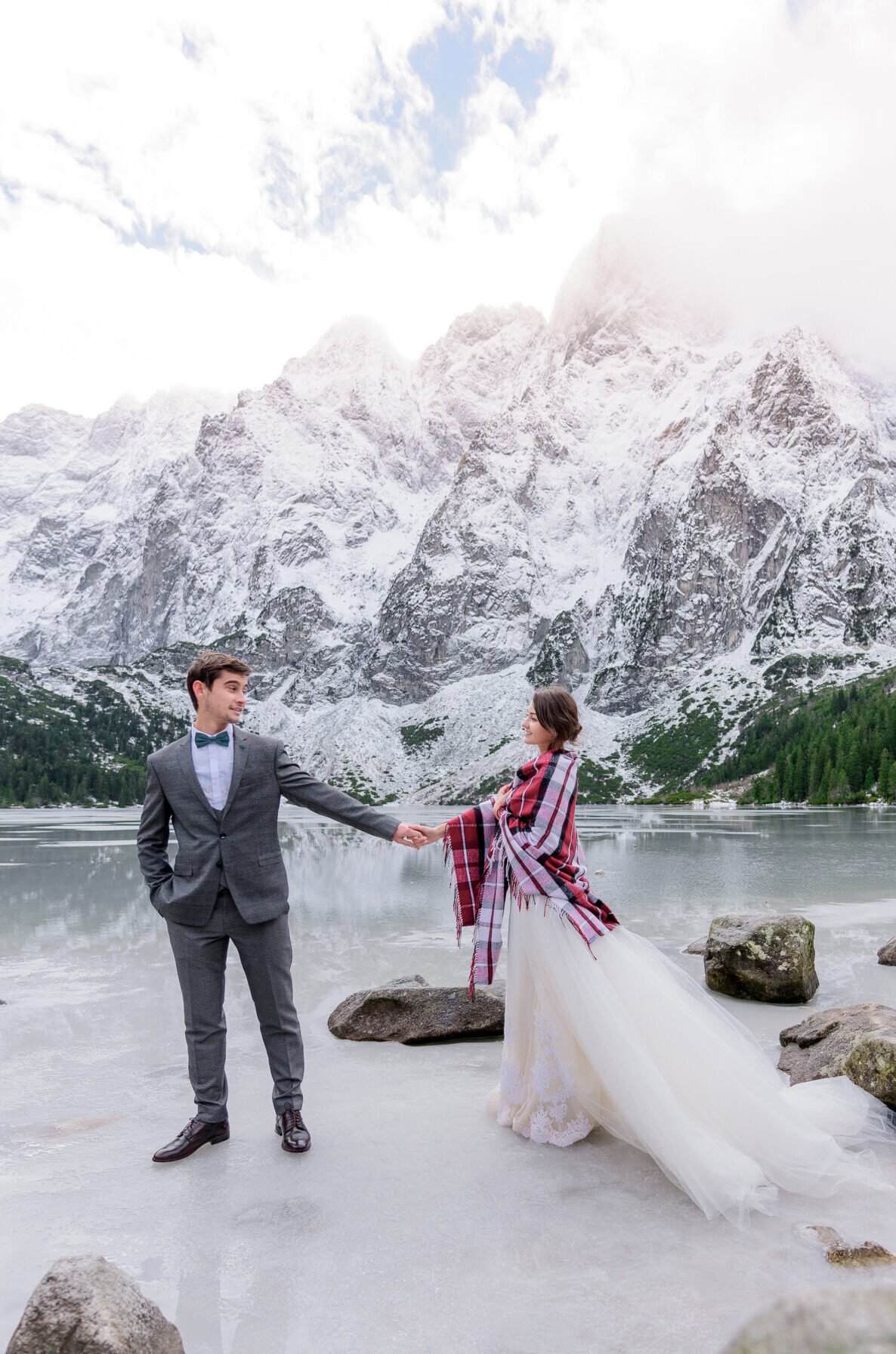 beautiful wedding couple is standing ice frozen highland lake with incredible winter mountain scenery scaled e1792053918288